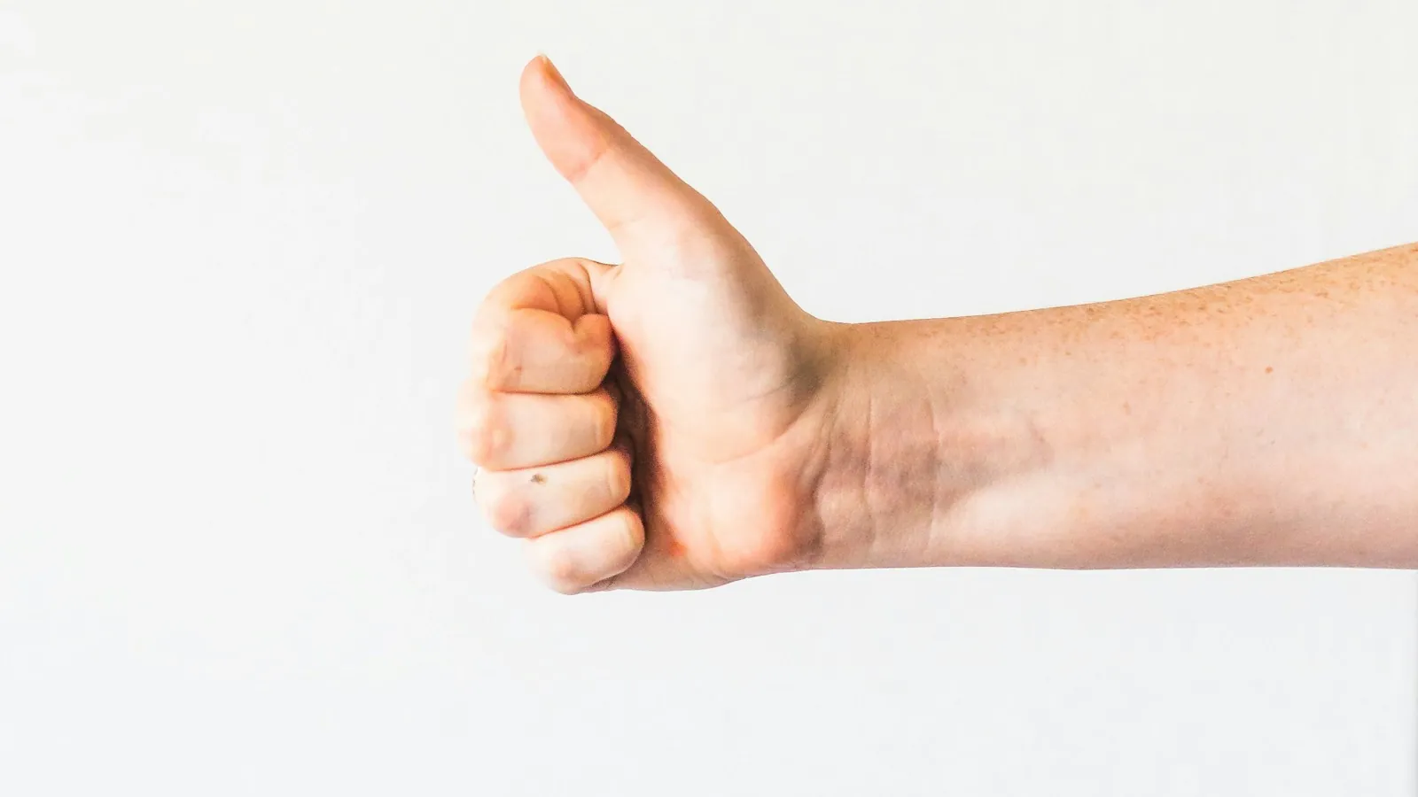 Persons right hand doing thumbs up